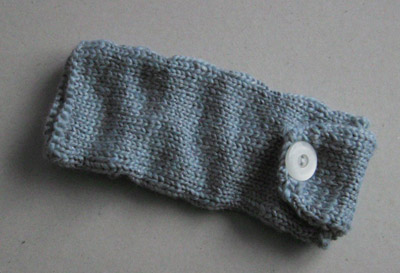 a pencil case knit out of gray yarn with silver threads running through it
